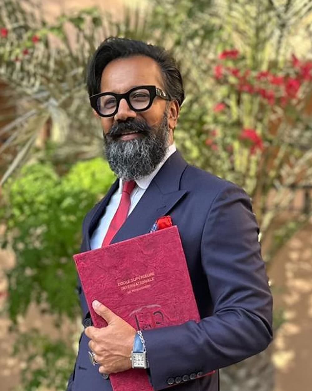 Portrait de Francis Dassou en costume bleu marine, tenant une pochette ESIP